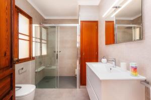 a bathroom with a shower and a sink and a toilet at Villa Cas Siulet in Alcudia +20 photos