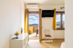 a living room with a door open to a balcony at Affittacamere Da Riccardo in Jerzu