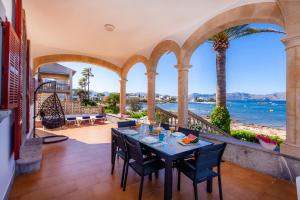 a patio with a table and chairs and a view of the ocean at Villa Cas Siulet in Alcudia