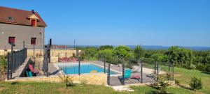 a swimming pool in a yard next to a house at Le petit nid du Quercy in Anglars-Nozac