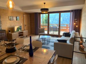 a living room with a couch and a table at Flambeaux A 12 Roca immobilier in Châtel