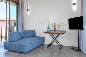 a living room with a blue chair and a table at Villa Mirtina - by And Service in Golfo Aranci
