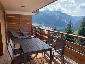 a table and chairs on a balcony with a view at Flambeaux A 12 Roca immobilier in Châtel