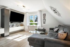 a living room with a couch and a tv at Haus Ankerplatz in Wischhafen