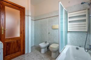 a bathroom with a toilet and a tub and a sink at Villafiorita in Alghero +12 photos