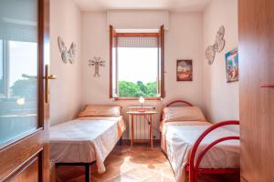 a small room with two beds and a window at Villafiorita in Alghero