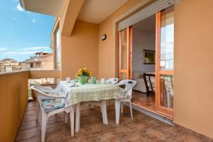 a dining room with a table and chairs on a balcony at Villafiorita in Alghero