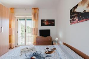 a bedroom with a bed with a television and a window at Casa Margiulu’ - Partanna in Partanna