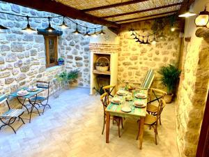 a room with a table and chairs and a stone wall at La Casuca in Olba