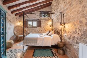 a bedroom with a metal bed in a stone wall at La Casuca in Olba