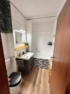 a bathroom with a sink and a toilet and a tub at Schwarzwald Martini in Sasbachwalden +17 photos