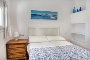 a bedroom with a bed and a dresser and a picture at Old Side Duplex Platja d Aro in Platja d'Aro