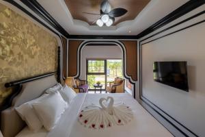 a bedroom with a bed with a ceiling fan at Cao Boutique Hotel in Thôn Trường Giang