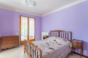 a bedroom with purple walls and a bed and a window at Maison Avec Vue Sur Le Ventoux in Faucon