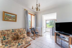 a living room with a couch and a flat screen tv at Maison Avec Vue Sur Le Ventoux in Faucon
