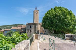 a building with a clock tower in a town at Maison Avec Vue Sur Le Ventoux in Faucon