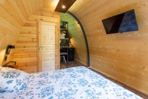 a bedroom with a bed and a flat screen tv at Pod insolite nature - vue verdure in Touët-sur-Var