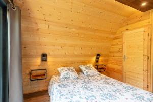 a bedroom with wooden walls and a bed in a room at Pod insolite nature - vue verdure in Touët-sur-Var