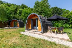 a small cabin with a table and an umbrella at Pod insolite nature - vue verdure in Touët-sur-Var