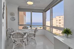 a dining room with a table and chairs and windows at Great views studio A84 in Torrox