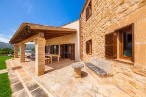 an outdoor patio with a bench and a table at Finca Mirador Capdepera in Capdepera