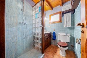 a blue tiled bathroom with a toilet and a shower at la casita in Las Pesas +15 photos