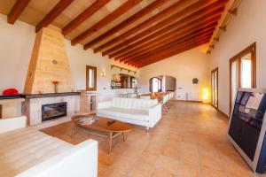 a living room with white furniture and a fireplace at Finca Mirador Capdepera in Capdepera