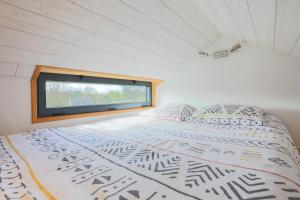 a large bed in a room with a window at Très Jolie Tiny House Tout Confort in Prat