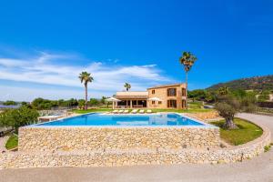 a villa with a swimming pool and a house at Finca Mirador Capdepera in Capdepera