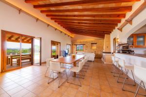 a kitchen and dining room with a wooden table and chairs at Finca Mirador Capdepera in Capdepera
