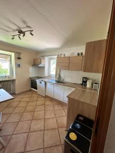 a kitchen with white cabinets and a tile floor at Haus Marianne in Bischofswiesen