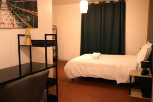 a bedroom with a white bed and a black curtain at La Parenthèse Saint-Etienne- Nevers in Nevers