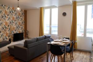 a living room with a couch and a table at La Parenthèse Saint-Etienne- Nevers in Nevers
