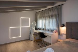 a bedroom with a bed and a desk and a window at Dias Guest House in Rethymno