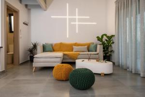 a living room with a couch and two ottoman at Dias Guest House in Rethymno
