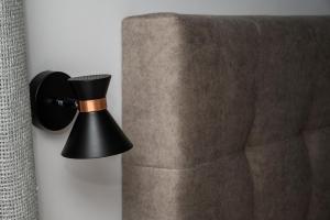 a black lamp on a wall next to a couch at Dias Guest House in Rethymno