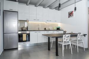 a kitchen with white cabinets and a table and chairs at Dias Guest House in Rethymno +32 photos
