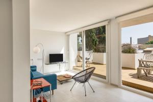 a living room with a blue couch and a sliding glass door at Apartamento L'escala - Bajos in L'Escala
