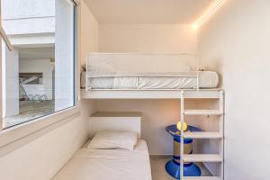 a small bedroom with bunk beds and a window at Apartamento L'escala - Bajos in L'Escala