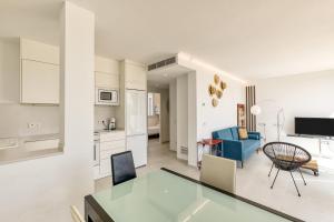 a kitchen and a living room with a blue couch at Apartamento L'escala - Bajos in L'Escala