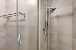 a shower with a glass door in a bathroom at Le Familiale in Bordeaux