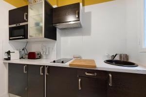 a kitchen with black cabinets and a sink at Le Familiale in Bordeaux +14 photos
