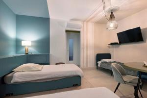 a bedroom with two beds and a table with a dining room at Le Familiale in Bordeaux