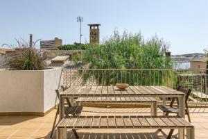 a patio with a table and benches on a balcony at Apartamento L'escala - Bajos in L'Escala