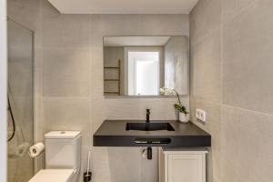 a bathroom with a sink and a mirror at Apartamento L'escala - Bajos in L'Escala +15 photos