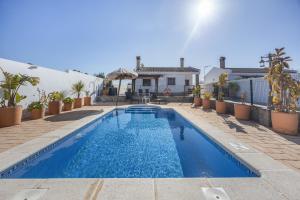 a swimming pool in front of a house at Chalet El Cancelín in Conil de la Frontera