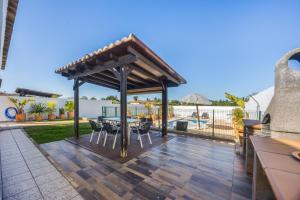 a gazebo on a deck with a table and chairs at Chalet El Cancelín in Conil de la Frontera