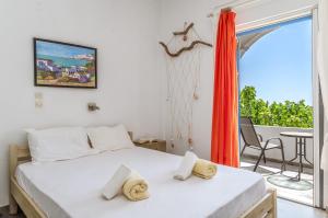 a bedroom with a bed and a balcony with a table at Perasma Studio 6 in Kipri