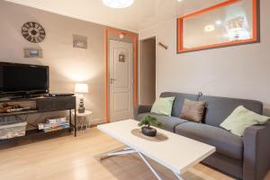 a living room with a couch and a table at Appartement T2 Les Pyrénées in Bagnères-de-Bigorre