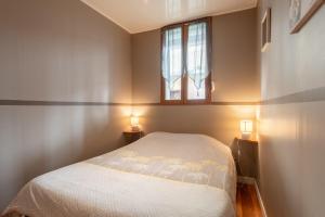 a bedroom with a bed and a window and two lights at Appartement T2 Les Pyrénées in Bagnères-de-Bigorre
